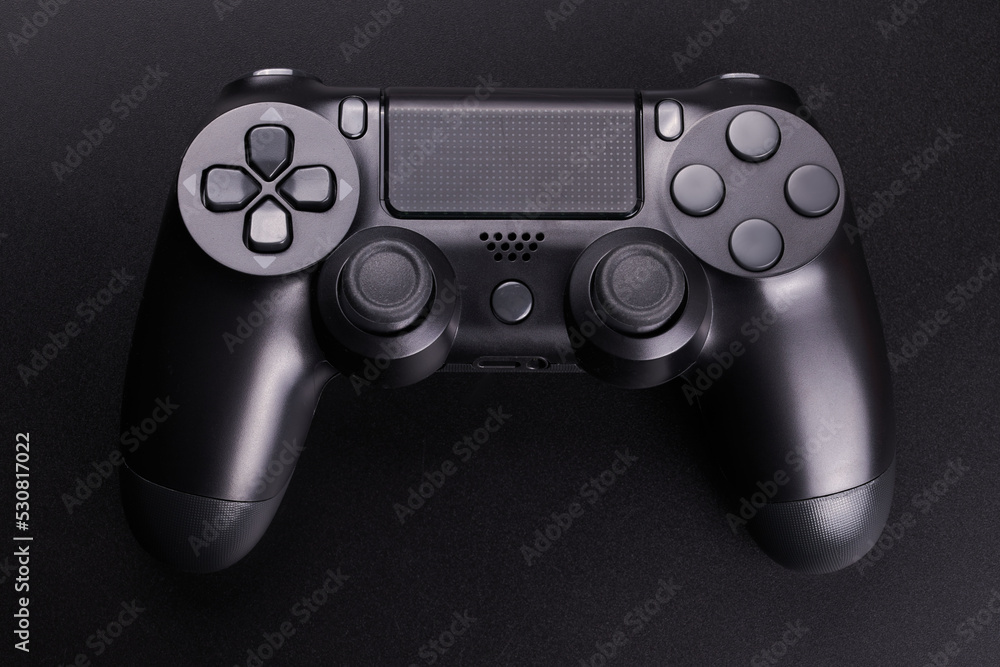 Black video game controller, joystick for game console isolated on black background. Gamer control device close-up Black video game controller, joystick for game console isolated on black background. Gamer control device close-up
