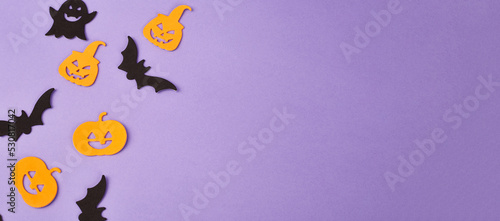 Halloween decorations  pumpkins  on violet background. Halloween party greeting card. Copy space. Flat lay  top view  overhead.