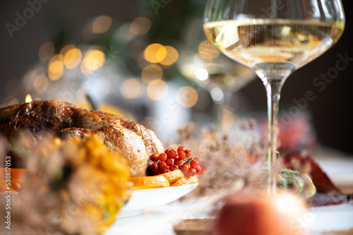Baked whole chicken or turkey for Christmas. Thanksgiving table with decoration  homemade roasted chicken  wine and salad of fruits  bokeh background