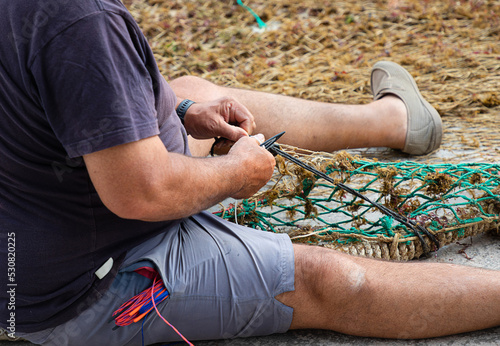 Photos Pescador arreglando su red de pesca en el puerto de Cala Figuera, junto al pueblo de Santanyí, en la isla de Mallorca (Islas Baleares, España)