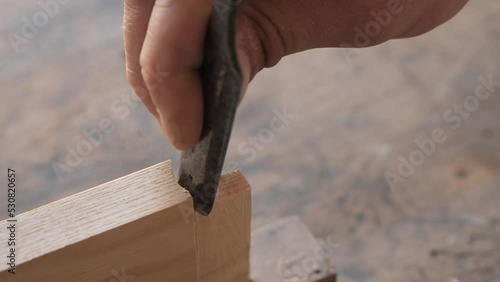 woodworker with chisel makes mortise and tenon 