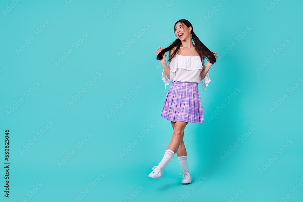 Full body photo of gorgeous positive person arms hold play black tails look empty space isolated on teal color background Full body photo of gorgeous positive person arms hold play black tails look empty space isolated on teal color background