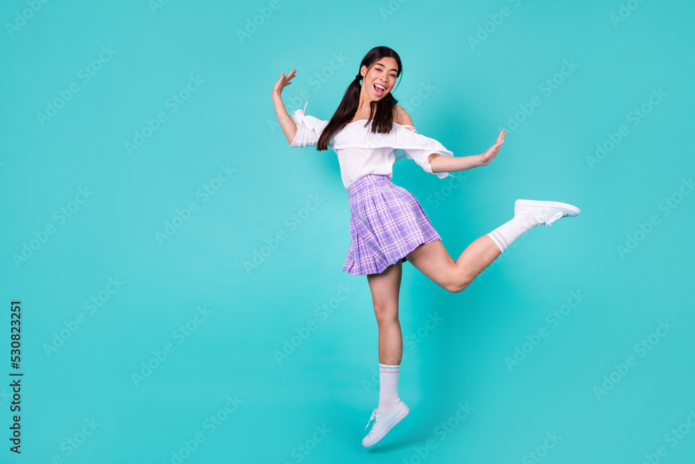 Full length photo of overjoyed gorgeous vietnamese girl jumping good mood isolated on emerald color background Full length photo of overjoyed gorgeous vietnamese girl jumping good mood isolated on emerald color background