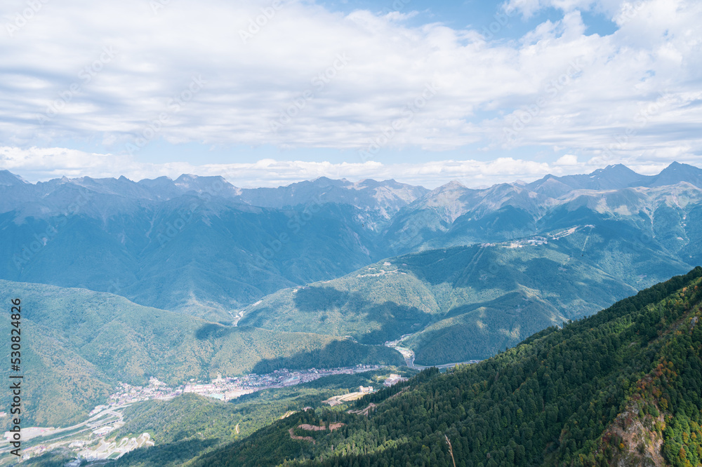 Alpine Meadows Trail, Krasnaya Polyana Resort. Alpine Meadows Walking Route. Aerial view of the green mountain valley, surrounded by high mountains. Alpine Meadows Trail, Krasnaya Polyana Resort. Alpine Meadows Walking Route. Aerial view of the green mountain valley, surrounded by high mountains.