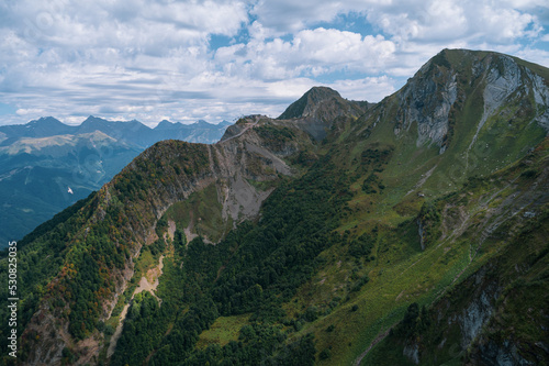 Alpine Meadows Trail, Krasnaya Polyana Resort. Alpine Meadows Walking Route. Aerial view of the green mountain valley, surrounded by high mountains. © Quatrox Production