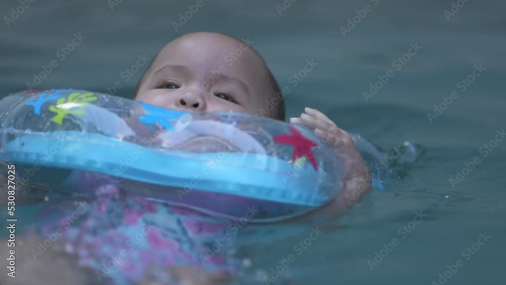 Cute Little Asian Baby a Year Old Toddler Child Swimming Using Blue Pool Floater Learn to Swim Slow motion Cute Little Asian Baby a Year Old Toddler Child Swimming Using Blue Pool Floater Learn to Swim Slow motion