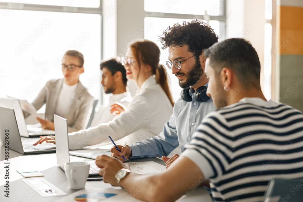 Busy coworkers cooperating and working together at office meeting, teamwork concept Busy coworkers cooperating and working together at office meeting, teamwork concept