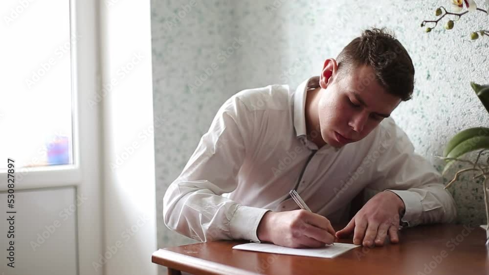 Man signs with a ballpoint pen on a white sheet of paper Office work Middle shot Man signs with a ballpoint pen on a white sheet of paper Office work Middle shot