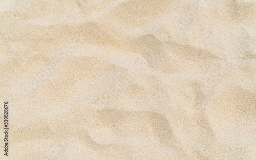 Sandy texture on the beach background with dry, top view brown sand 