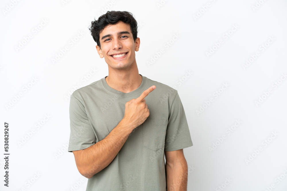 Young Argentinian man isolated on white background pointing to the side to present a product Young Argentinian man isolated on white background pointing to the side to present a product