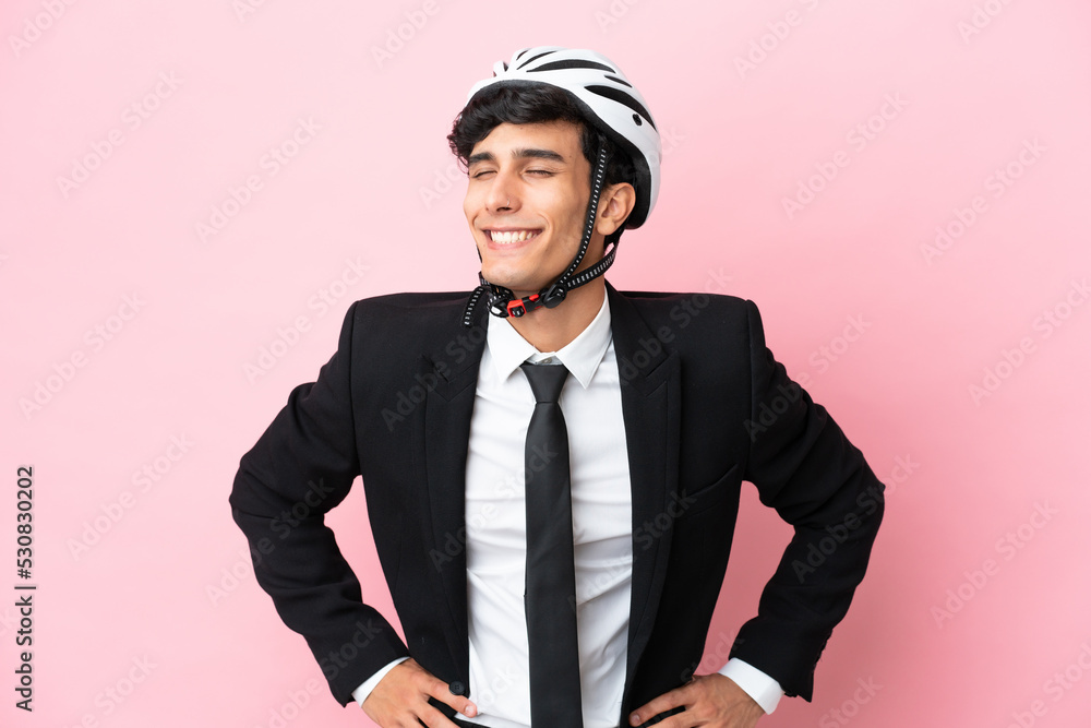 Argentinian businessman with bike helmen isoleted on pink background Argentinian businessman with bike helmen isoleted on pink background