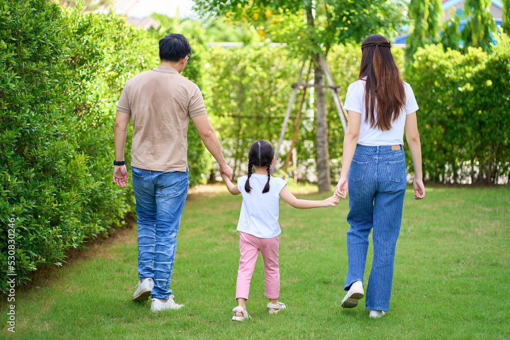 Happy Asian Family enjoying family walking time together in the park