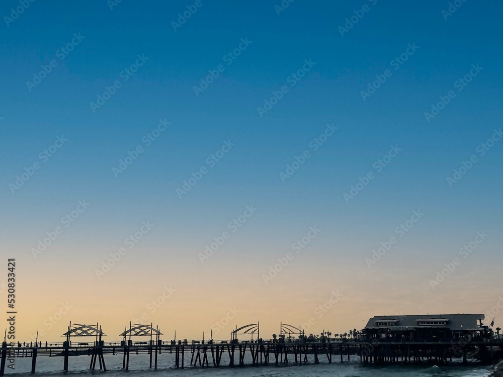 beautiful view of wooden bridge on the sea during the sunset in the autumn season.