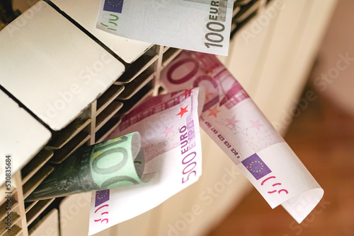 Euro banknotes in a central heating radiator, the concept of expensive heating costs in energy crisis