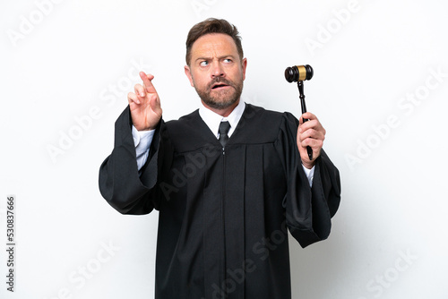 Middle age judge man isolated on white background with fingers crossing and wishing the best