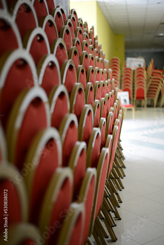 rows of red and gold cinema and theater chairs for spectators and audiences
