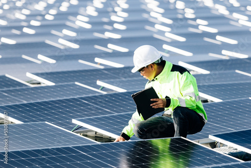 The portrait of a asian young engineer checks photovoltaic solar panels. Concept. renewable energy technology electricity service, green power.