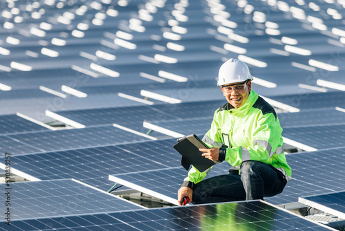 The portrait of a asian young engineer checks photovoltaic solar panels. Concept. renewable energy technology electricity service, green power.
