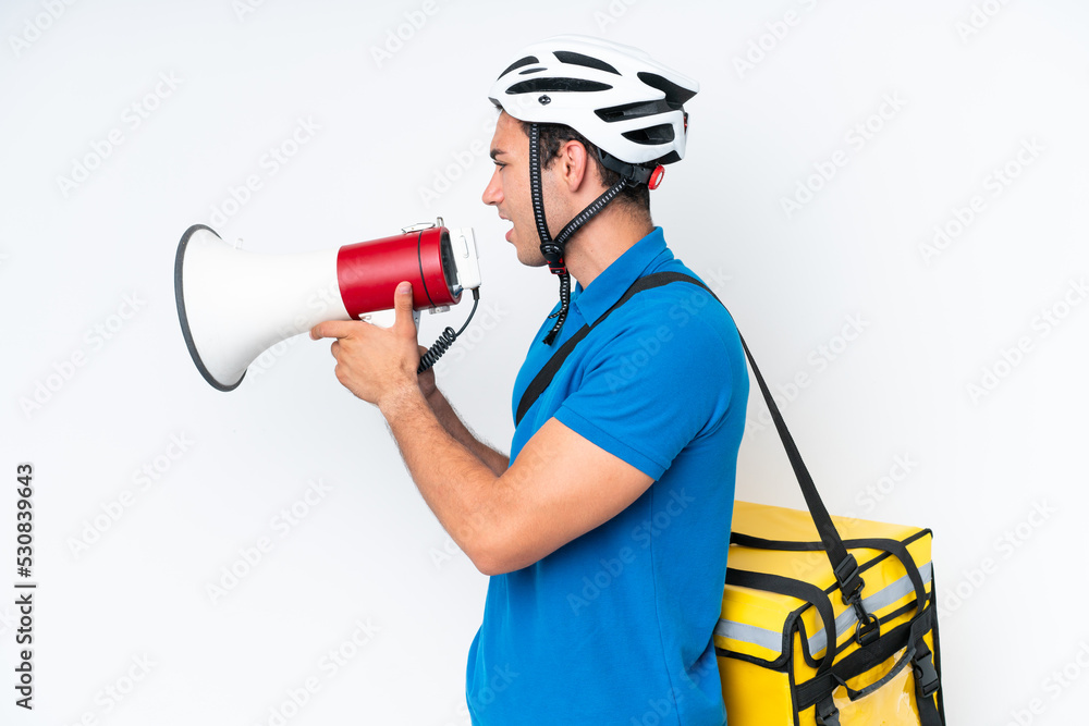 Young caucasian man with thermal backpack isolated on white background shouting through a megaphone Young caucasian man with thermal backpack isolated on white background shouting through a megaphone
