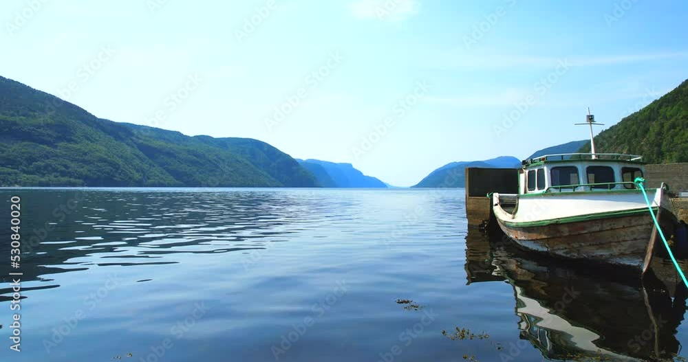 Boat tied to the shore by a house in a fjord, Northern Europe aerial footage in HDR Boat tied to the shore by a house in a fjord, Northern Europe aerial footage in HDR