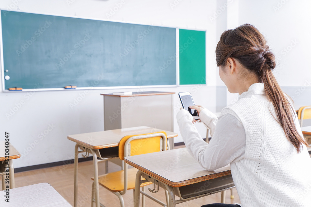 教室で携帯電話を使う学生