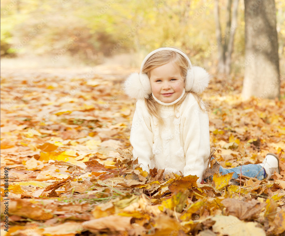 Happy blonde little girl portrait dressed in fur earmuffs Happy blonde little girl portrait dressed in fur earmuffs