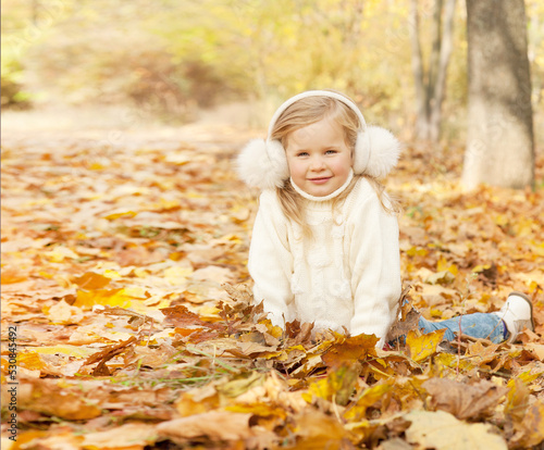 Happy blonde little girl portrait dressed in fur earmuffs