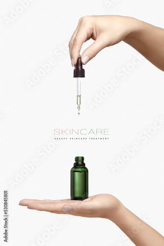 Skincare cosmetic ads. Graceful female hands holding a cosmetic dropper bottle over a white background with copyspace photo