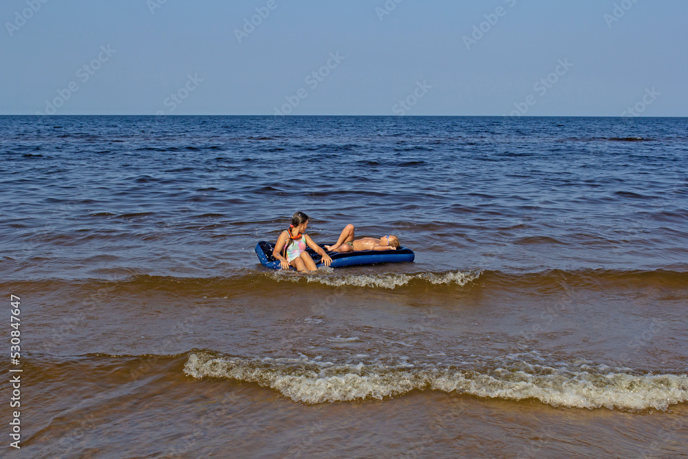 children on an air mattress on the water children on an air mattress on the water