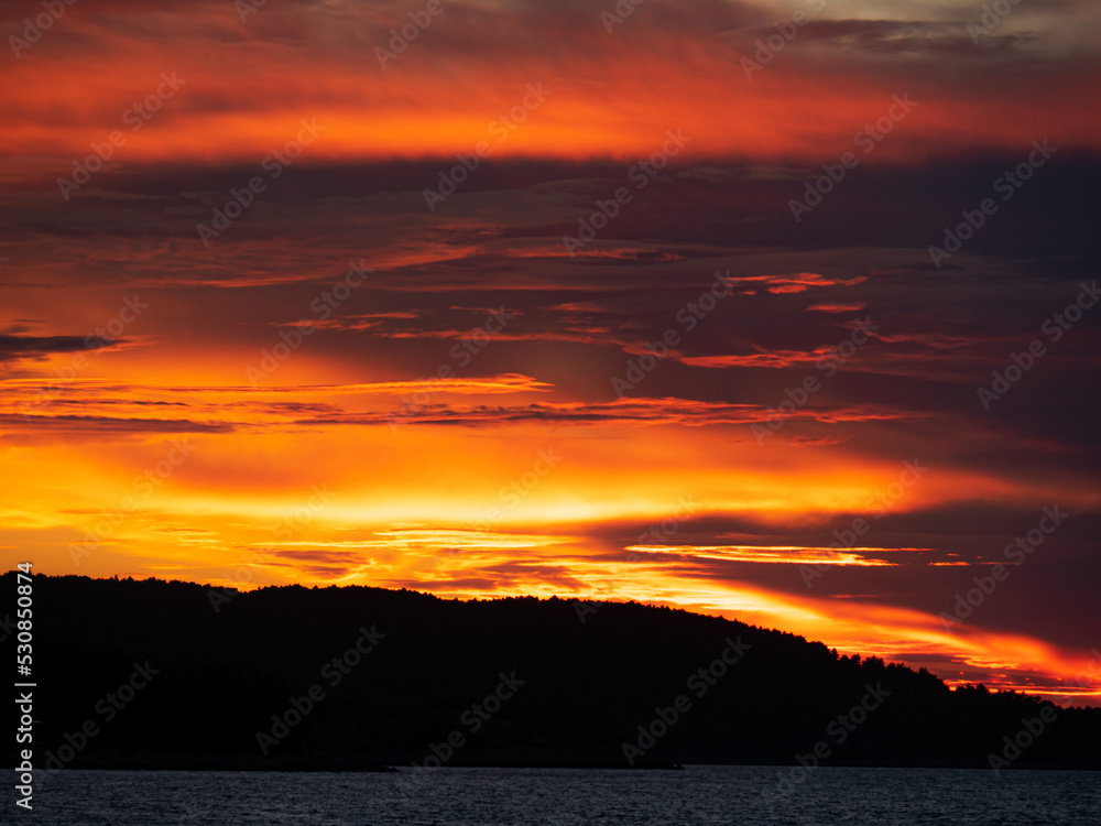 a wonderful orange sunset with the sea and land in the background a wonderful orange sunset with the sea and land in the background