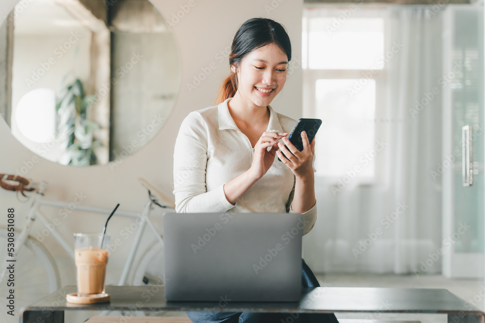 Asian girl. Beautiful woman enjoys talking on the phone in the house by the window. Asian girl. Beautiful woman enjoys talking on the phone in the house by the window.