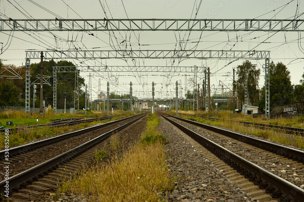 railway, in the photo straight lines of railway tracks against a gray sky railway, in the photo straight lines of railway tracks against a gray sky