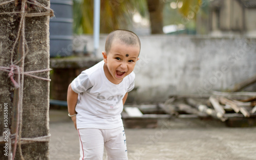 Cute smart naughty baby making a funny and looking at camera. Happy baby background.