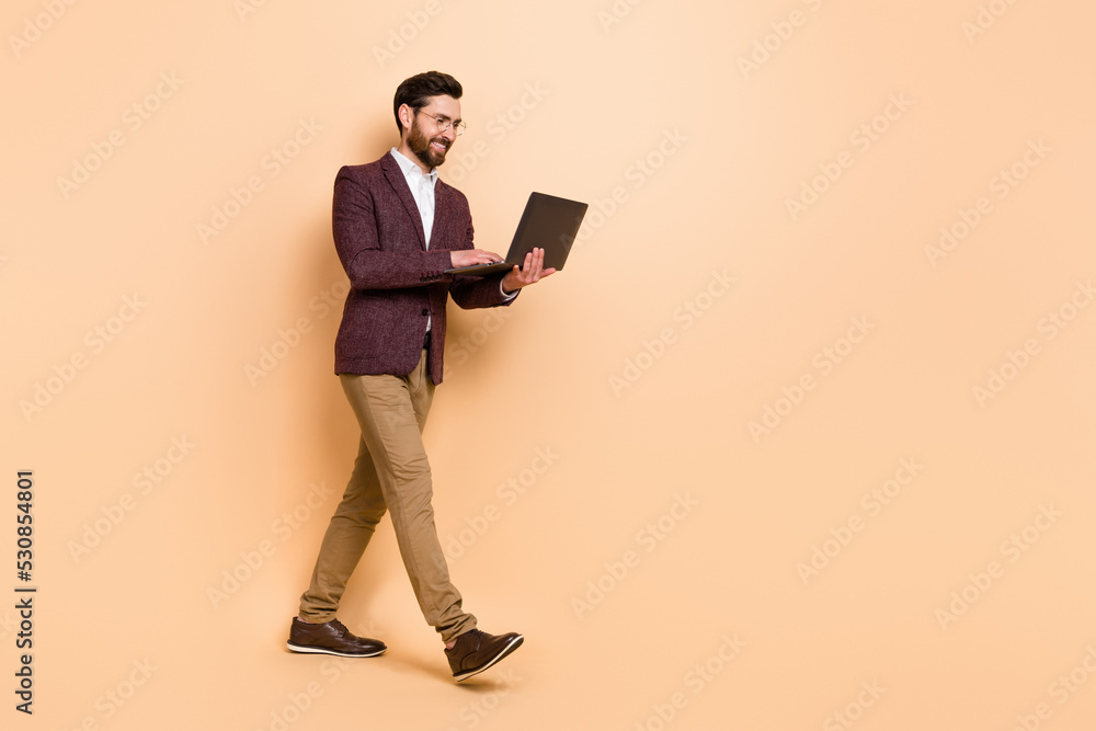 Full body profile side photo of intelligent businessman can't stop working isolated on beige color background Full body profile side photo of intelligent businessman can't stop working isolated on beige color background