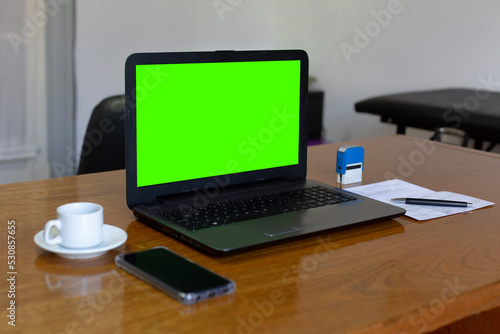 Close up view of doctor s office laptop with mock up green screen browsing internet at work desk. Healthcare medical e health website technology concept.