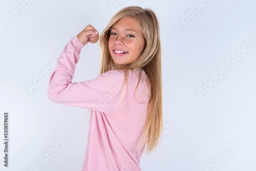 Wallpaper Mural caucasian blonde little girl wearing pink jacket and glasses over white background ,  showing muscles after workout. Health and strength concept. Torontodigital.ca