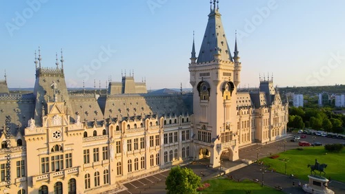 Aerial drone view of the Palace of Culture in Iasi downtown at sunset, Romania. Square with Stephen the Great statue, people and greenery in front of it, buildings around photo