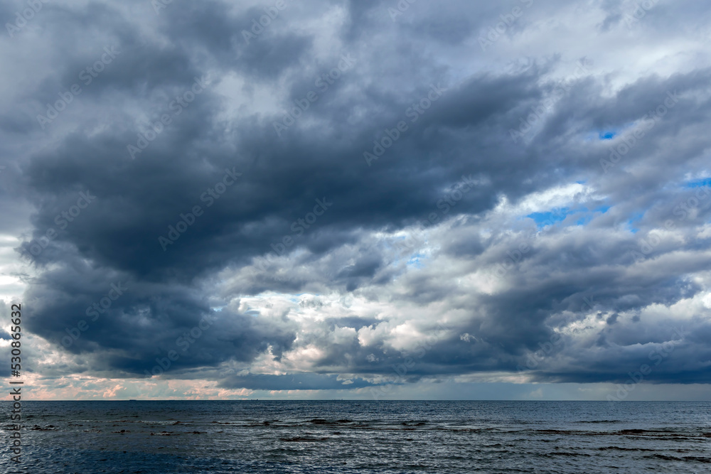 	
Dramatic stormy dark cloudy sky over Baltic sea just before a sea storm in Riga, Latvia. Nature environment concept. Gloomy and moody background.
