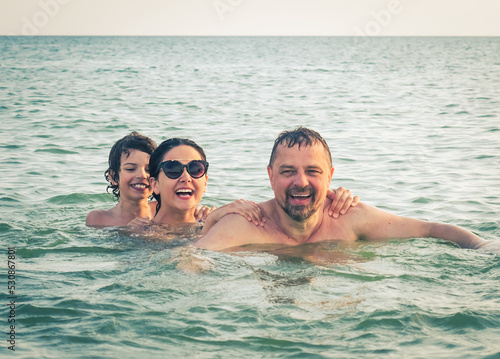 Dad, daughter and son bathe swimming in the sea and having fun together. Paternity concept © kravik93