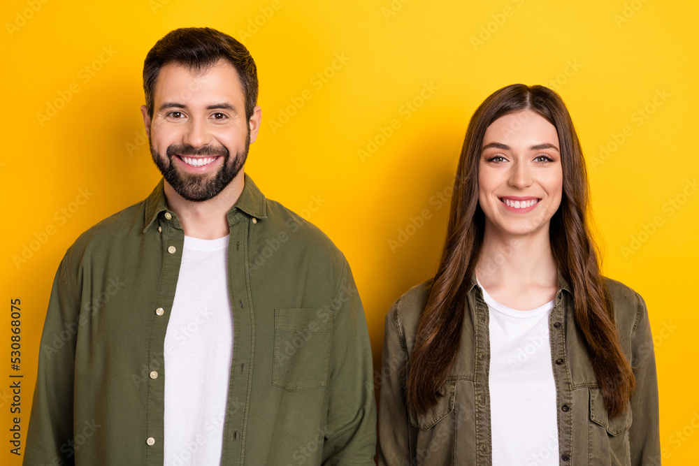 Portrait of cheerful nice partners toothy beaming smile look camera isolated on yellow color background Portrait of cheerful nice partners toothy beaming smile look camera isolated on yellow color background