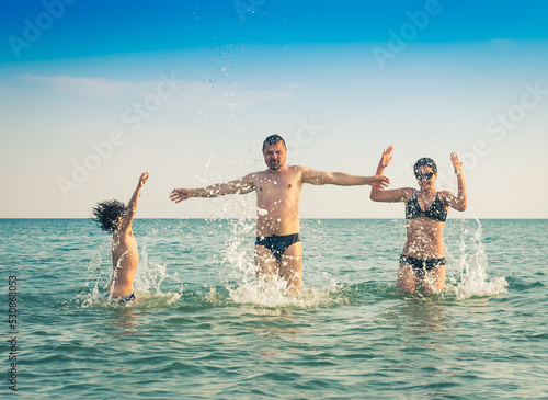 Dad, daughter and son bathe swimming in the sea and having fun together. Paternity concept