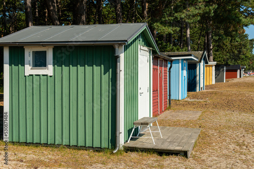 Little cozy tiny wooden multicolored houses on a beach in Sweden. Sunny summer day. © Bohdan