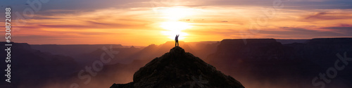 Epic Adventure Composite of Man Hiker on top of a rocky mountain. Dramatic Sunset Sky. 3d Rendering peak. Background landscape from North America. Freedom Concept.