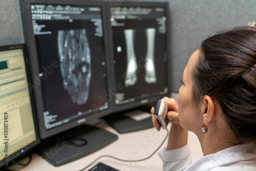 Leinwand Poster radiology doctor examines foot, ankle x-ray, mr image and reports with microphone looking computer screen, X-ray analysis room reading X-rays of a chest and other parts of the body