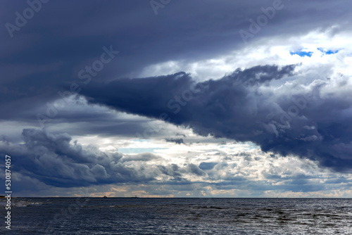 Funnel - shaped horizontal clouds on stormy dark cloudy sky over Baltic sea just before a sea storm in Riga  Latvia. Nature environment concept. Weather Forecast Concept.