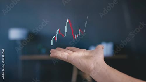 Apeared hand shows stockmarket chart animated as hologram candlessticks graph, futuristic concept of stock trading photo