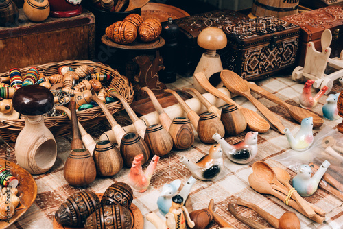 Various wooden handmade souvenirs at street market stall or souvenir shop for tourists. Wooden easter eggs pysanka  pipes  ceramic whistles. Traditional Ukrainian handicrafts