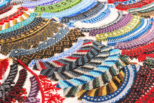 Colorful beaded necklaces - traditional Ukrainian etnic style jewelry in vibrant colours, hutsul herdan or gerdan. Handmade necklaces at souvenir stall or street market. Selective focus photo
