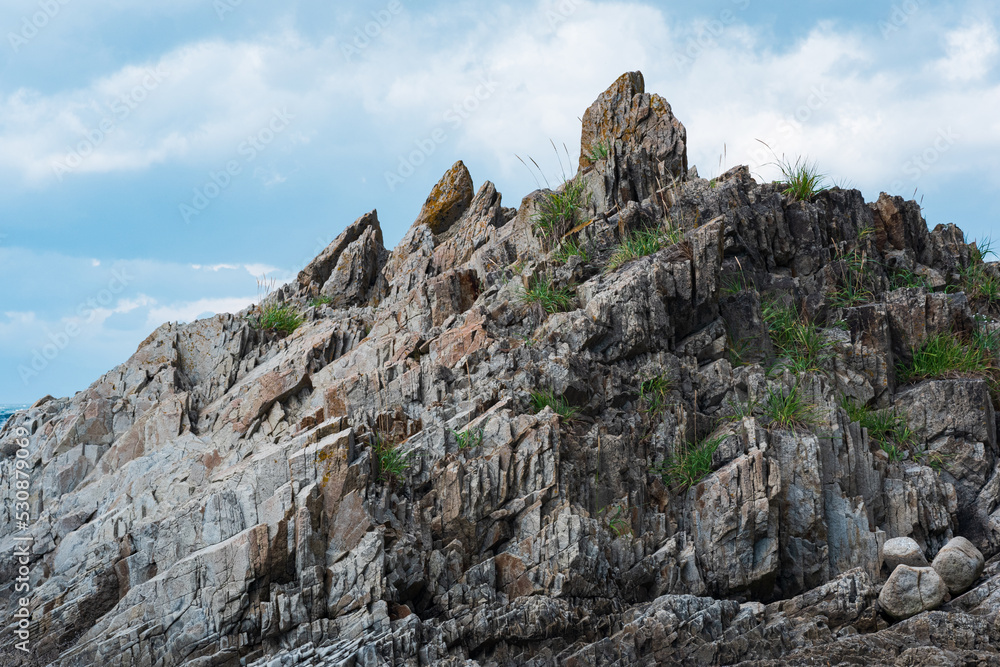 top of a steep rocky cliff of volcanic basalt against the sky