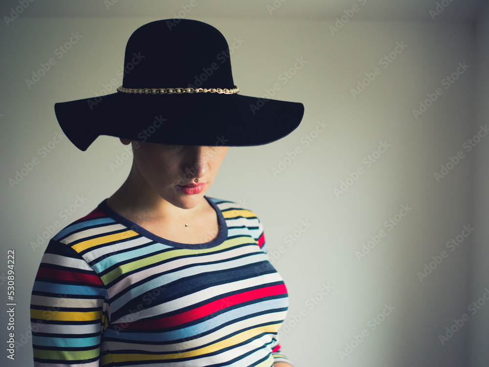 Young elegant bald woman suffering from cancer standing beside window at home Young elegant bald woman suffering from cancer standing beside window at home